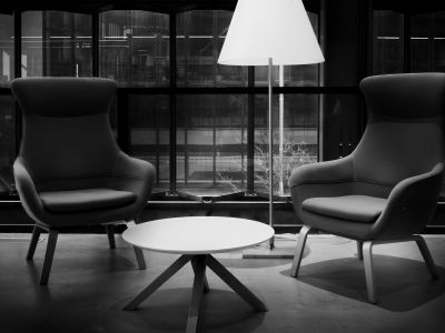 Two armchairs facing each other across a low table, with a lamp in the corner.